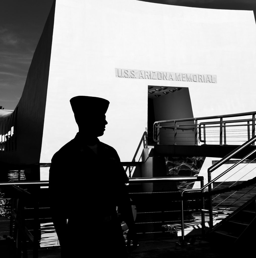 US Navy sailor at the USS Arizona Memorial in Pearl Harbor, Hawaii. I love the silhouette of the sailor against the stark white of the memorial. I was fortunate to capture his profile as he walked past.